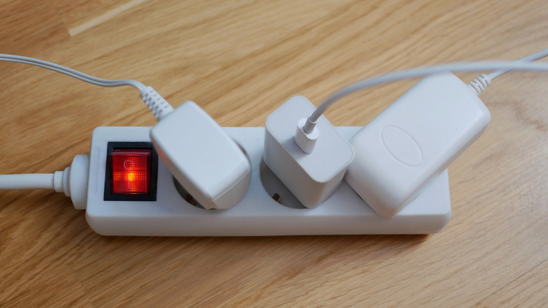 Charging cords are plugged into an electrical strip.