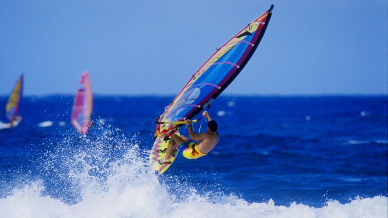 windsurfer catching a wave in blue ocean