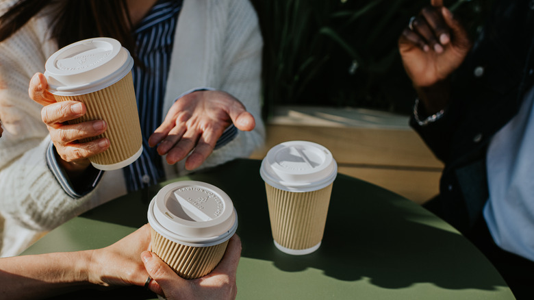 group of friends enjoy coffee drinks from takeaway cups