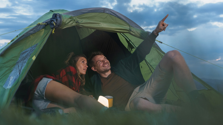 couple stargazing in tent