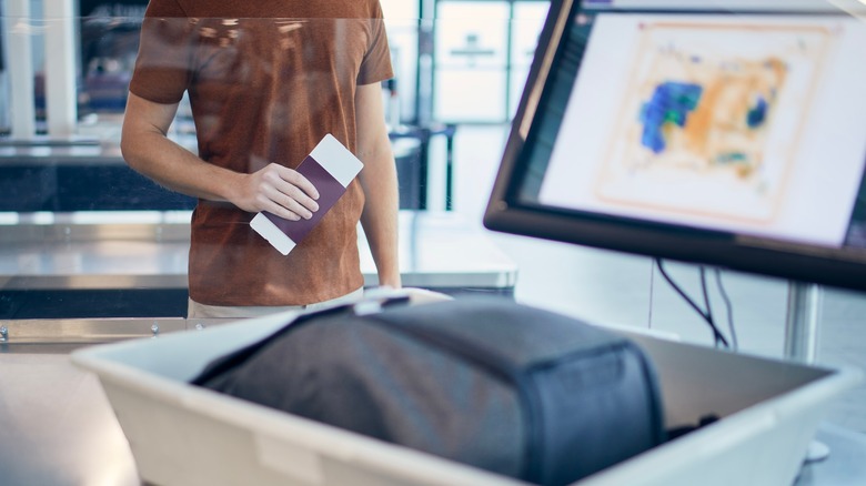 person waiting for luggage x-ray