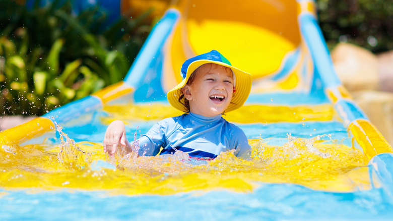 Child smiling on water slide