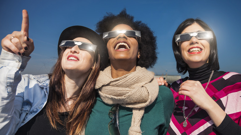 group of friends in eclipse goggles