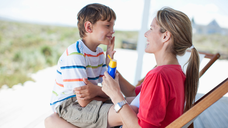 mother putting sunblock on son