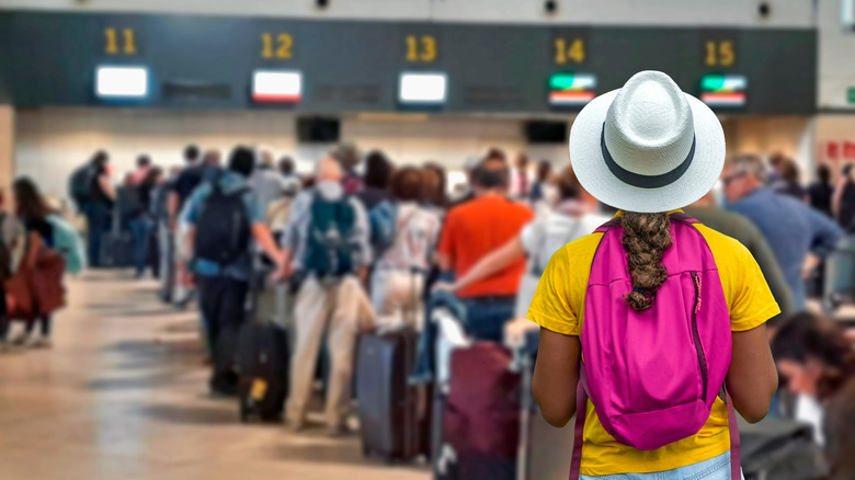 A woman waiting in line at a busy airport