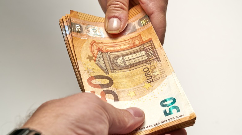 Two hands exchanging notes
