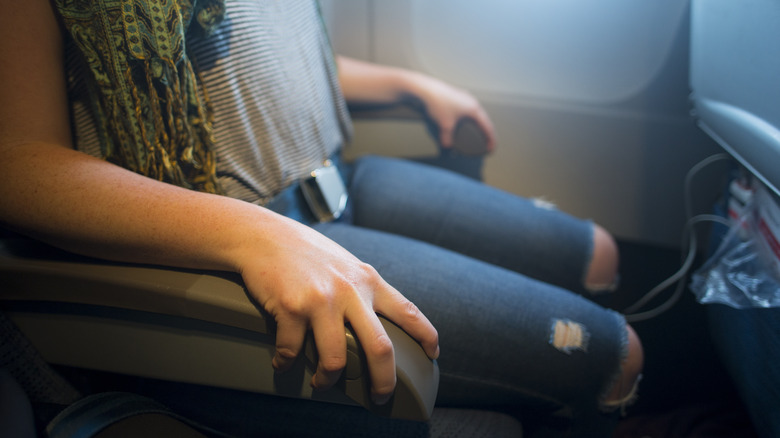 Woman taking middle seat armrest