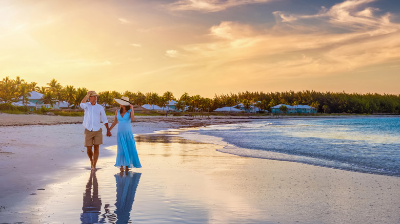 A couple walking along the beach in the Caribbean.