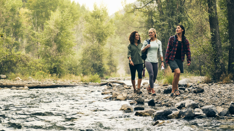 Young women hiking along water