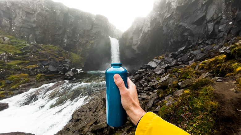 Water bottle visually under a waterfall