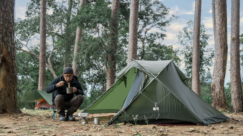 Camper eating a meal outside their tent