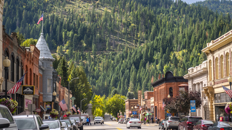 A street running through a historic silver mining town in front of pine forest-covered mountains