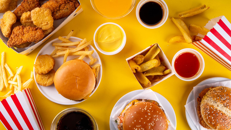 Burgers, fries, and other fast food on a yellow table