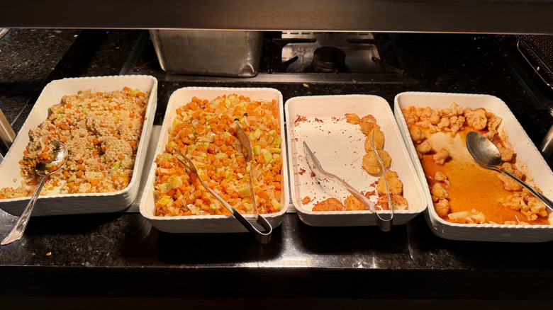 Trays of orange food on a hotel buffet