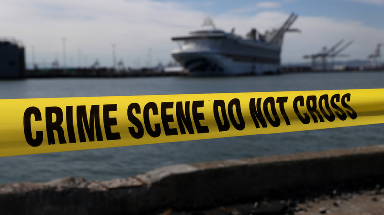 Crime scene tape is stretched in front of a cruise ship
