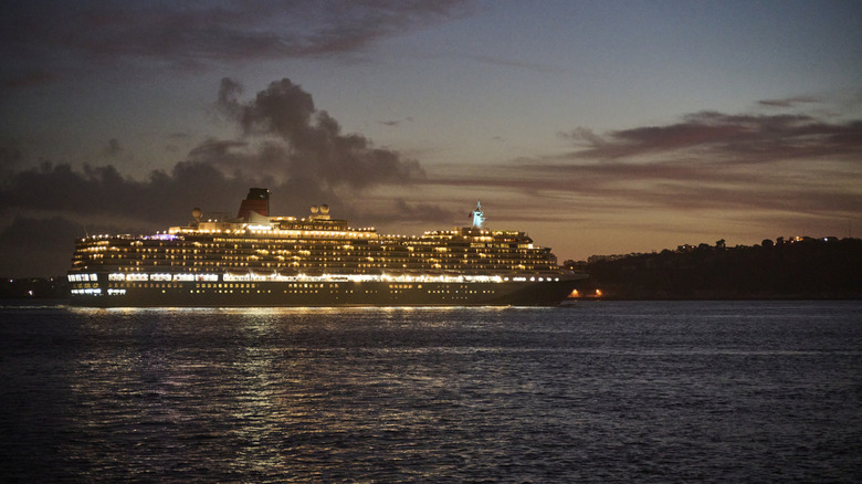 A cruise ship crosses dark waters at night