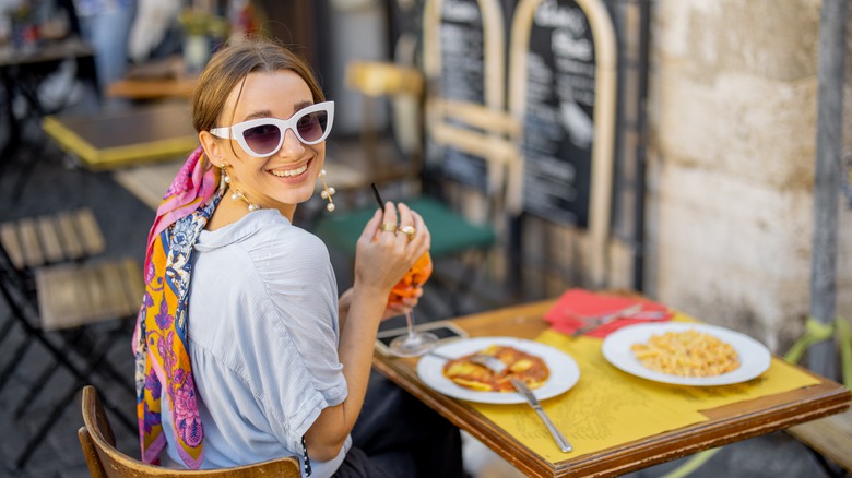 woman drinking spritz and eating