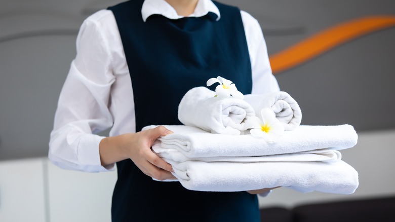 hotel housekeeper holding towels