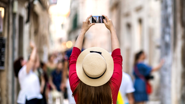 Woman photographing street with her phone