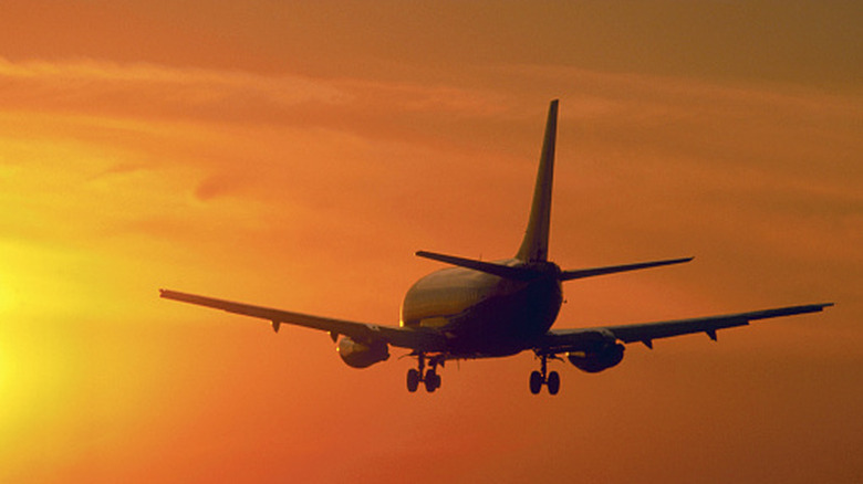 An airplane flying into the sunset.