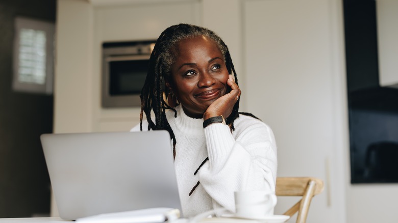 woman smiling near her laptop