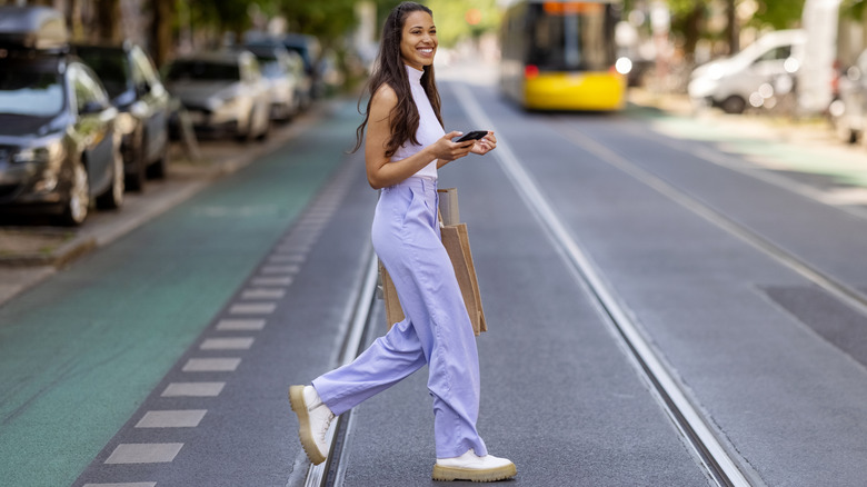 Woman smiling walking across street