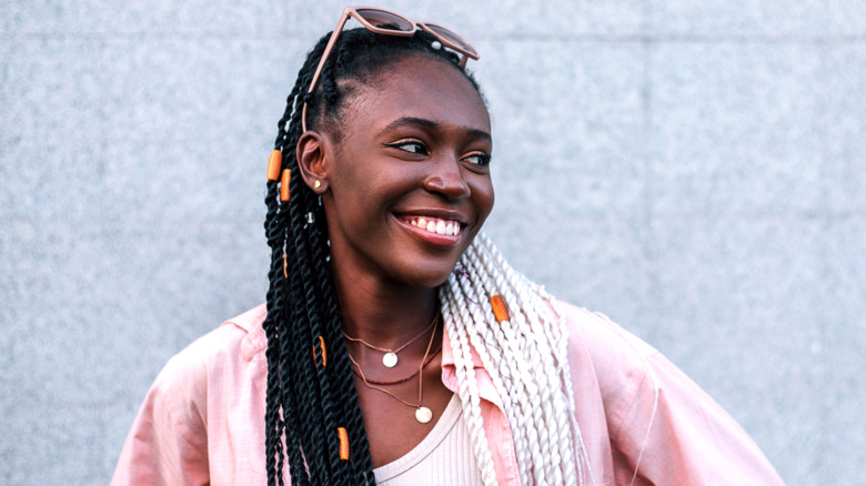 Woman smiling with sunglasses and necklaces