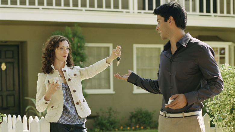 Woman handing keys to man