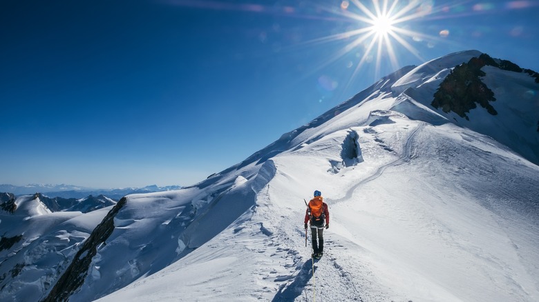 person hiking snowy high altitude mountain