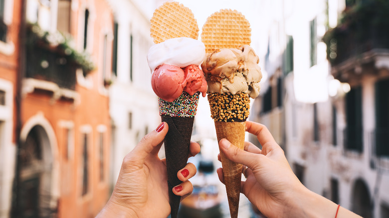 Two people holding gelato in Italy