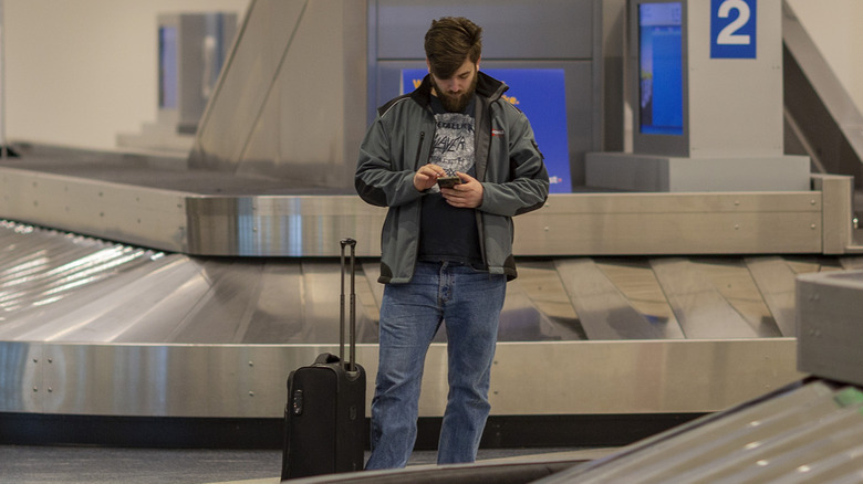 lone passenger at empty baggage carousel