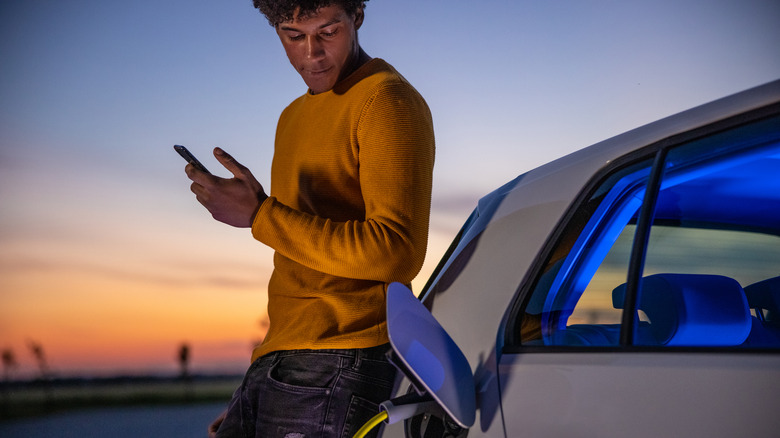 man charging electric vehicle