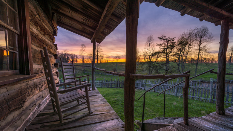 A rustic log cabin at sunset