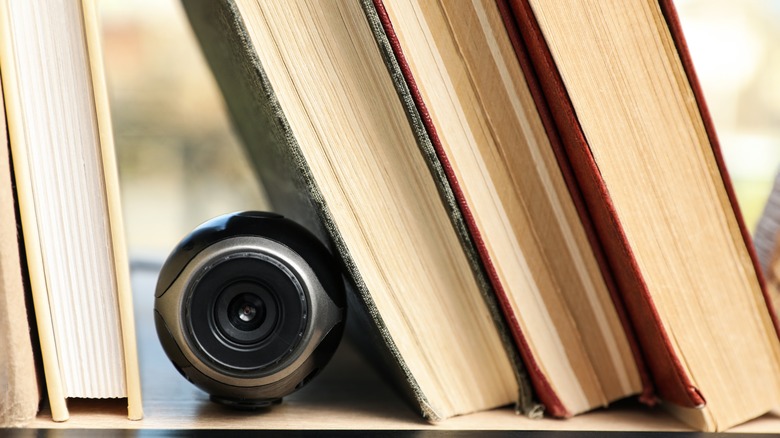 small camera hidden on a bookshelf