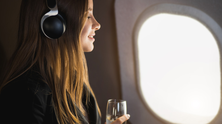 woman holding champagne on flight