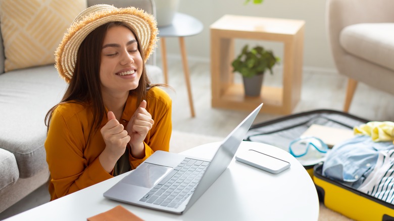 woman looking hopeful at laptop