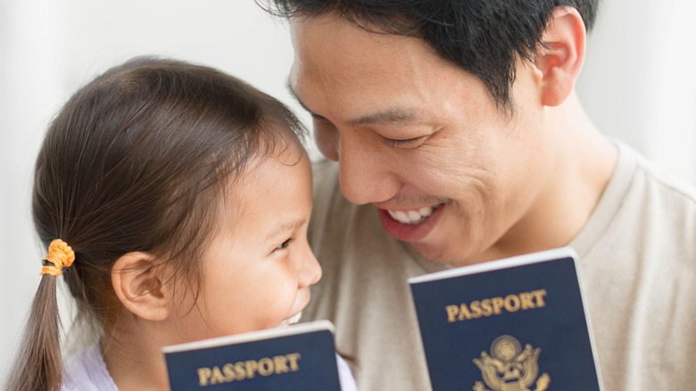 man and child holding passports