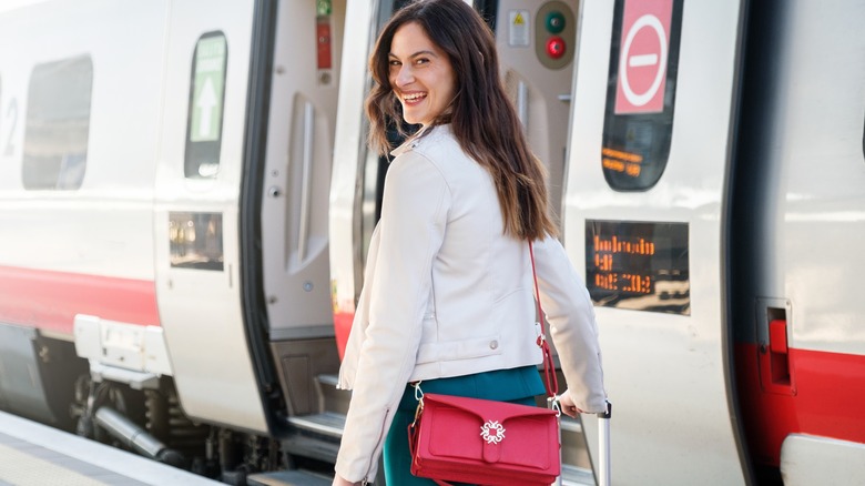 woman walking to train with suitcase