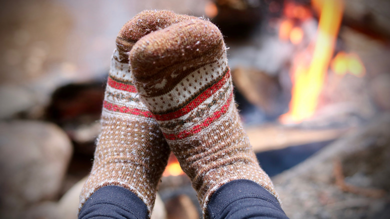 feet with Merino socks near campfire