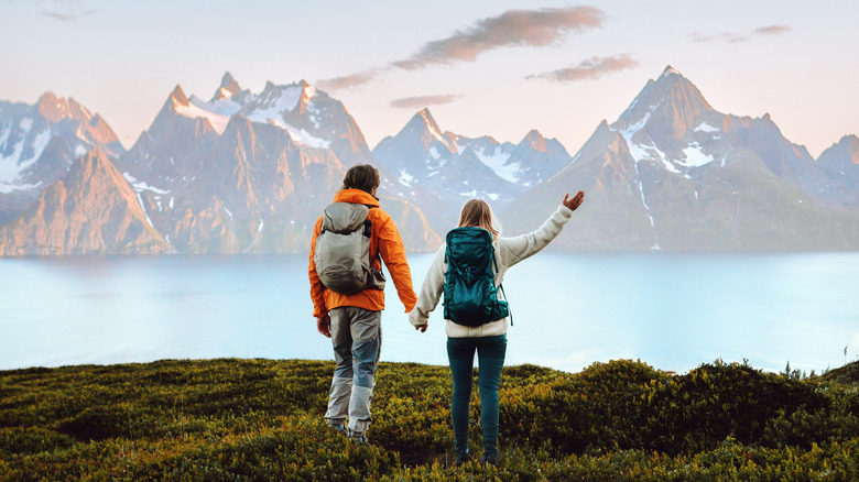 couple hiking in mountain setting by a lake