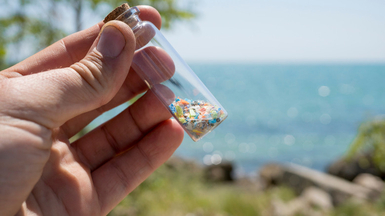 close up of microplastics in a jar, next to water