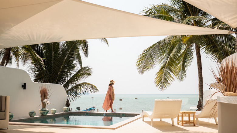 Woman walking along pool at luxury resort