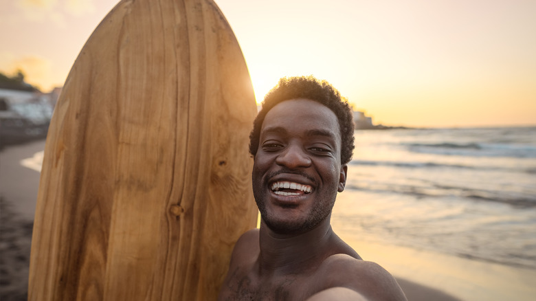 Smiling man with a surfboard