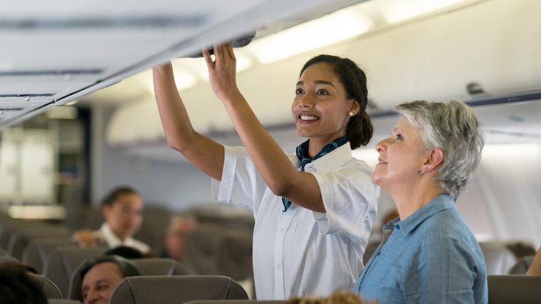 flight attendant helping a passenger