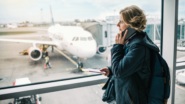 A woman uses her cellphone at the airport.