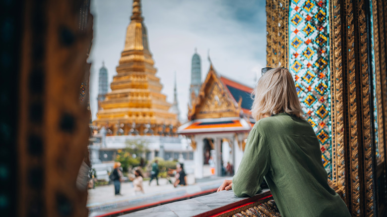 woman looking out window at temple