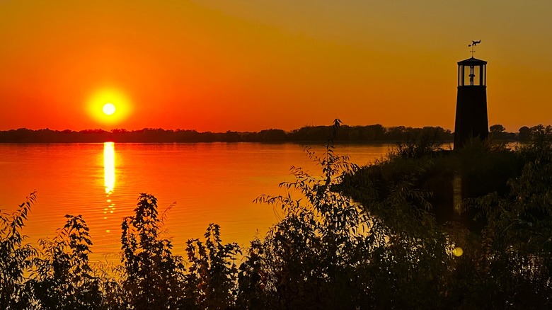 A beautiful sunset near a lighthouse along glacial Storm Lake in Iowa