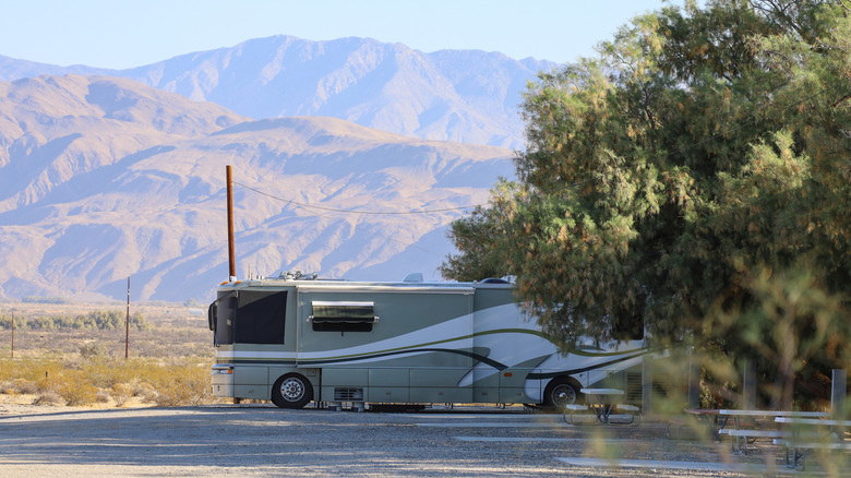Large RV parked with mountains in backdrop