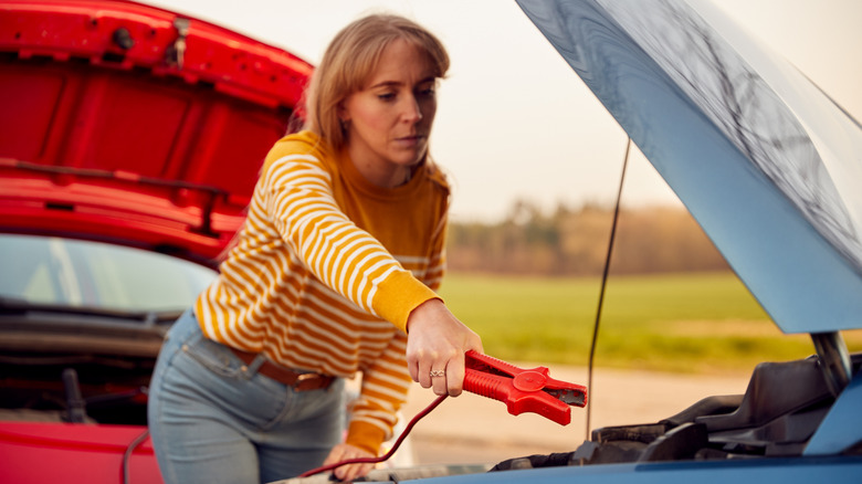Woman using jumper cables