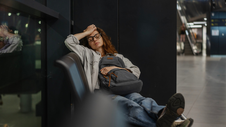 Young sleeping woman at train station